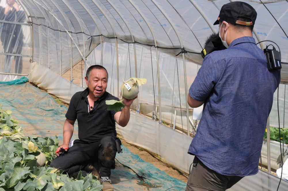 収穫したメロンを手に取り 「このメロンは、5日後に食べてね」などと 参加者1組1組に、丁寧に説明する米川さん。